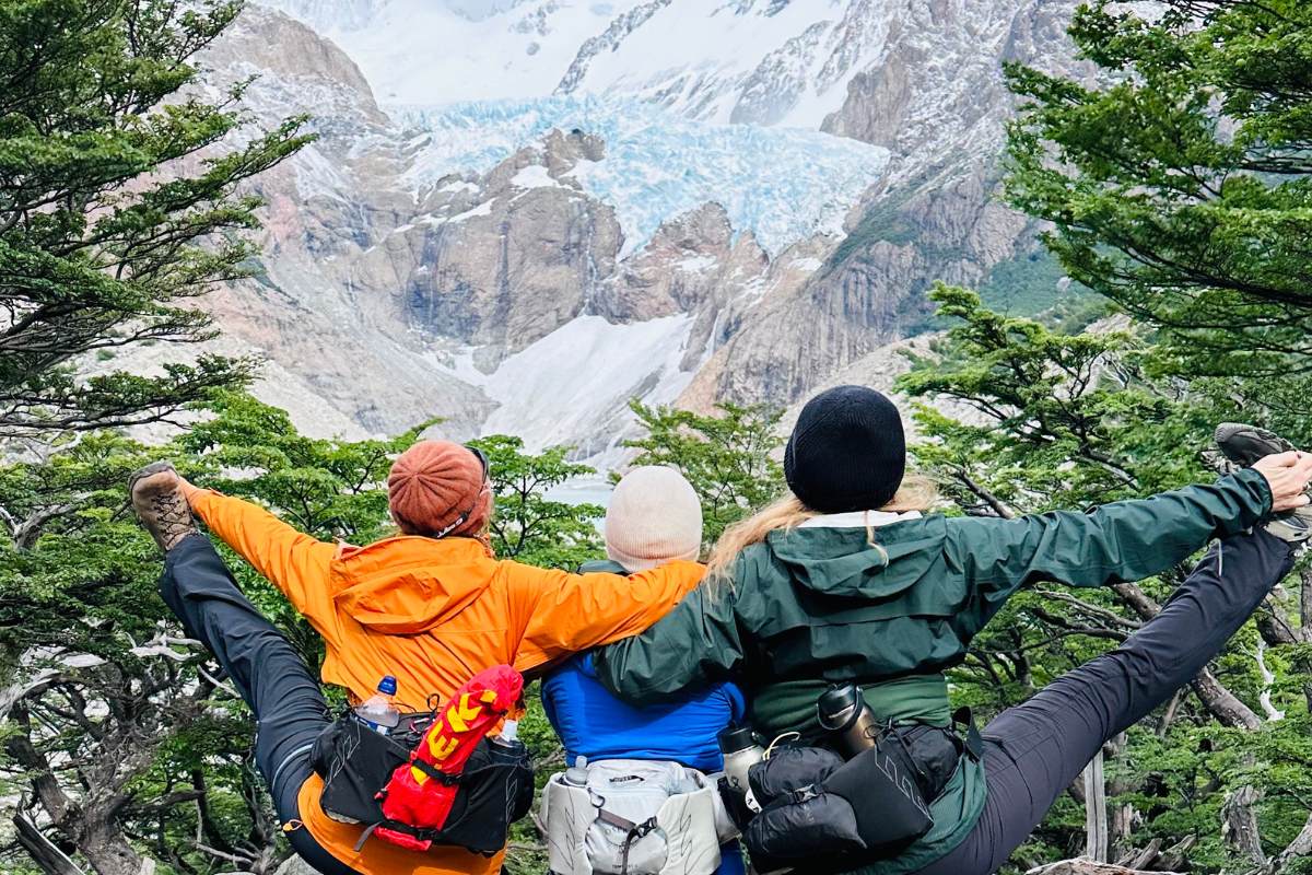 women practicing yoga on a hike in front of a glacier in los glacieres national park in patagonia