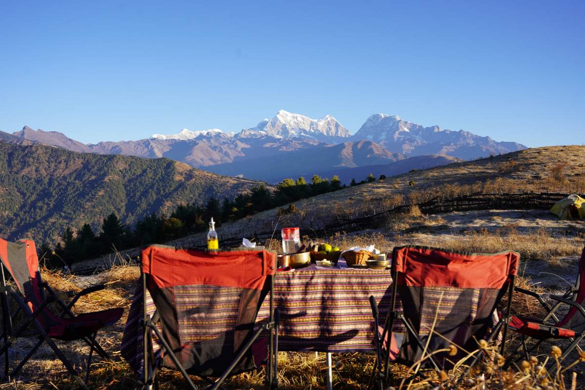 a lunch table with a view of the himalayas in the background
